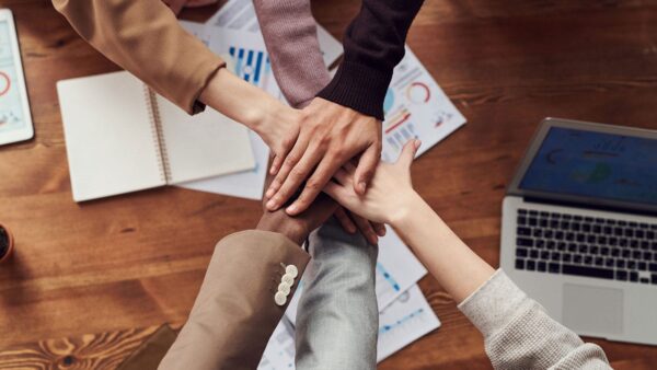 A marketing team putting their hands together over a table